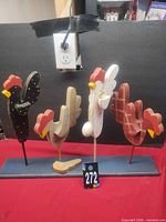 Front view of all four mounted wooden chickens showing patterns and overall size