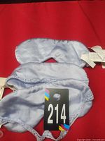 Three light blue satin eye masks displayed on red background