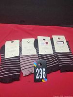 Four pairs of new Zara striped socks with tags displayed on red surface