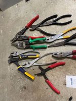 Group of pliers and tin snips on concrete floor