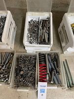 Top view of three bins showing mixed springs, red springs and green lag screws