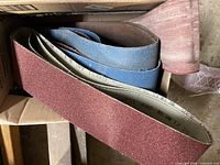 close-up of spare sanding belts in box