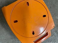 Top view of orange retractable extension reel showing model markings and winding knob