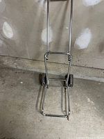 Unfolded view of metal folding dolly showing frame, handle and wheels