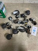 Group of assorted casters on concrete floor displaying different styles and sizes