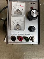 Front panel showing GEM brand, ammeter, voltmeter, binding posts, controls