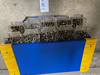 Top compartments of cabinet with flip lids holding screws