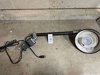 Full view of lamp showing arm, cord, clamp, and lamp head