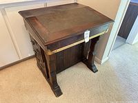 Front and side view of mahogany Davenport desk showing leather inset top, brass trim, carved side panel, leg design
