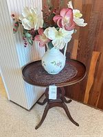 Full view of side table with pitcher, flowers and doily