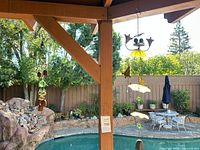 Wide view of both wind chimes hanging from patio beam over pool