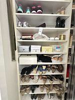 Tall shelving unit filled with multiple pairs of women’s shoes and several shoe boxes