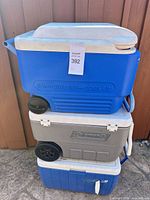 Front view of stacked coolers showing brands, wheels and lids