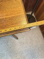 close view of side table top with measuring tape showing approximate width