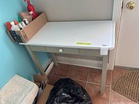 Full view of painted wood accent table with metal top and drawer