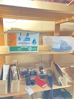 Overview showing garbage bag box, plastic bin, timers, casters, brackets, work light on shelving