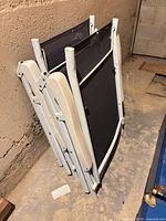 Two folded lounge chairs leaning against wall
