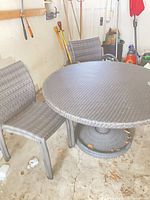Round rattan table with two chairs visible