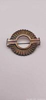 Front view of circular scalloped sterling brooch with central bar