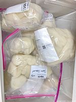 Multiple labelled resealable bags containing white wool roving