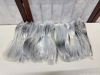 All 75 spoons bundled in plastic sleeves on table