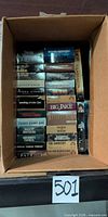 Box of 31 VHS tapes showing assorted movie titles