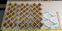 Four wood lattice panels and two white plastic frames laid flat with measuring tapes for scale
