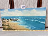 Full view of unframed oil seascape on canvas showing beach, waves, sky