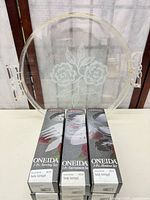 Overall lot showing three boxed Oneida flatware sets and clear acrylic tray with etched floral design