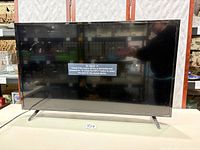 Front view of Vizio TV powered on displaying no-signal message
