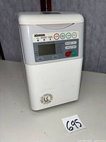 Front and side view of Zojirushi bread maker showing control panel, logo and general condition