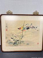 Full view of framed print showing ducks, grasses, lilies and wood frame