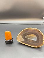 Carved stone seal on stand beside Brazilian agate slice