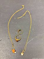 Overview of two chains with pendants and two rings