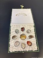 Open box showing nine stones in padded satin interior