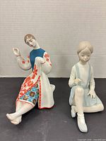 Both porcelain figurines side by side showing size and decoration