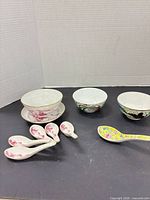 Overview of three bowls, matching saucer, seven soup spoons