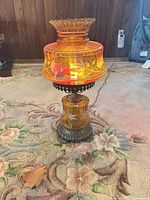 Lamp assembled showing amber glass shade and metal base