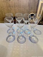Seven clear wine glasses grouped on table