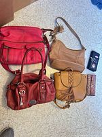 All four handbags and two wallets laid out for overview