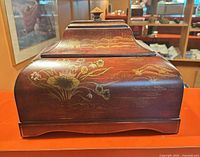 Front view of Bombay wood jewelry box showing gold floral and landscape painting
