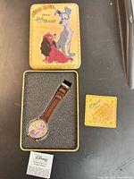 Watch in open tin box with certificate and leaflet