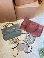 Overview showing all five items: teal satchel, rust tote, floral crossbody, grey wristlet, floral wallet