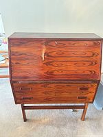 Front view of closed rosewood drop-front bureau showing grain and drawers