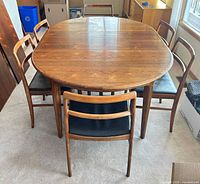 oval rosewood dining table with six chairs