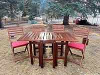Full view of table with four chairs and cushions outdoors