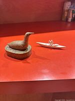 Stone bird figurine and bone kayak side by side