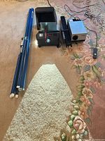 Full lot showing projector projecting light, sorter, trays, screen and remote