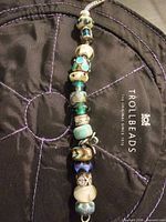 Full view of bracelet displaying beads and sterling chain on Trollbeads pouch