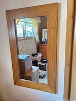 Full view of mirror mounted on wall reflecting room